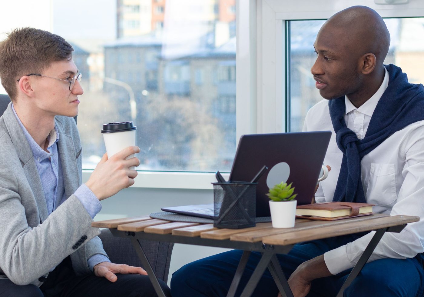 An accountant and a financial planner talking at a window table