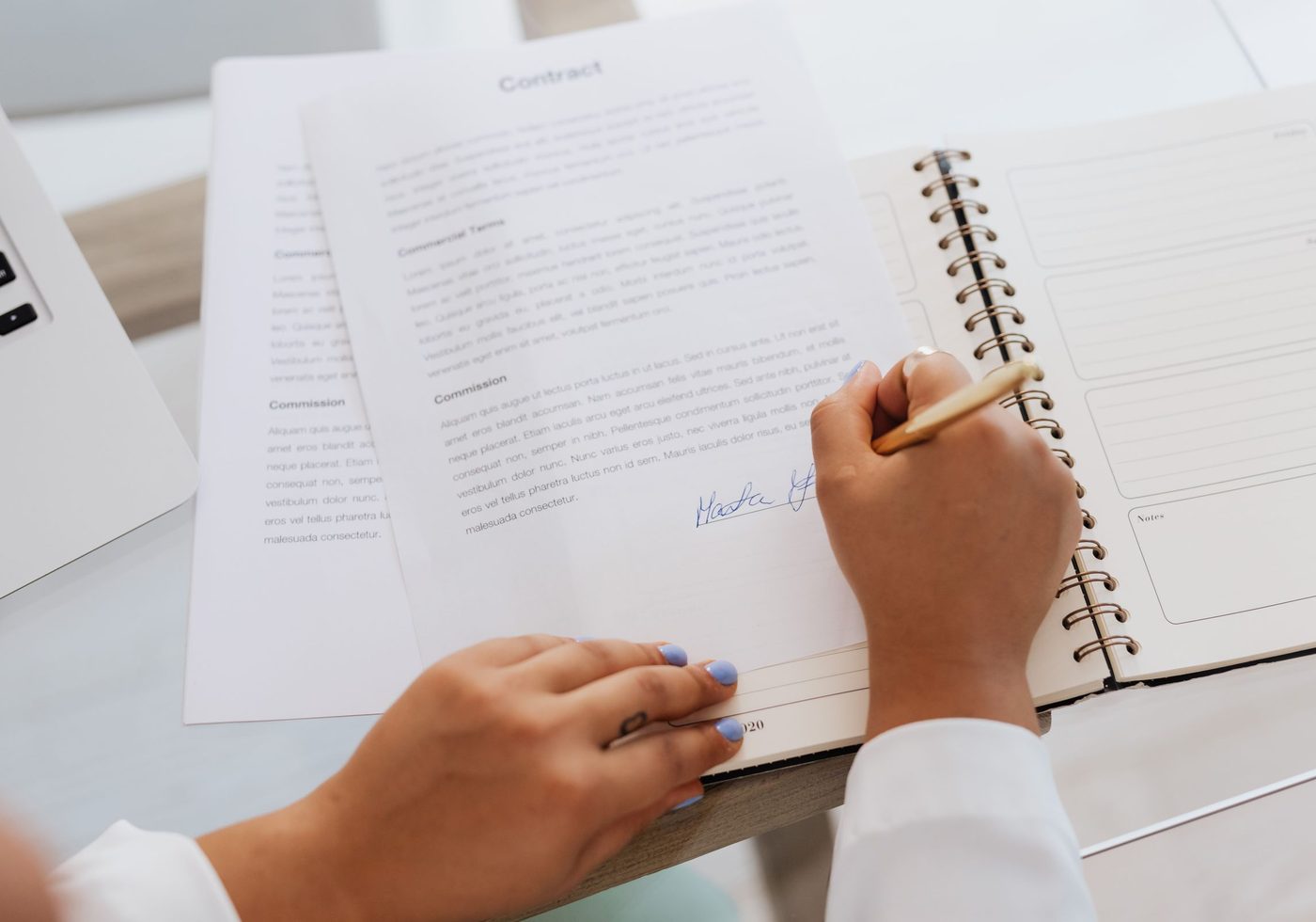 A contract and notebook on a desk