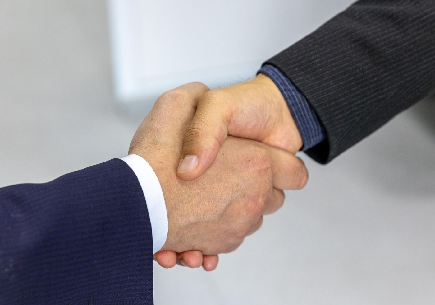 Two business owners shaking hands on a sale